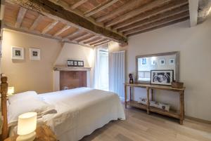 a bedroom with a white bed and a fireplace at Radicondoli House in Radicondoli