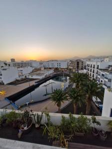 a view of a city with a pool and palm trees at Casa sofia in Arrecife