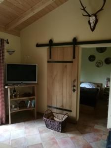 a living room with a tv and a sliding door at Jagdhaus Franz in Krahne