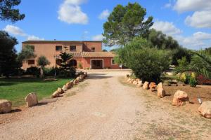 a dirt road leading to a building with trees and rocks at Son French in Algaida