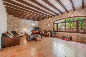 a large living room with a stone wall at Son French in Algaida