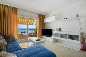 a living room with a blue couch and a television at Ceyla in Arona