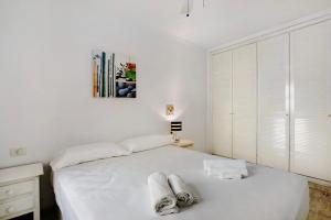 a white bedroom with a bed with towels on it at Ceyla in Arona