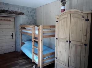 a bunk room with two bunk beds and a cabinet at Ferme Des Montagnes Bleues in Bellegarde-en-Diois