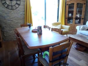 a dining room with a wooden table and chairs at Ferme Des Montagnes Bleues in Bellegarde-en-Diois
