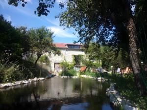 a view of a river with a building in the background at Ferme Des Montagnes Bleues in Bellegarde-en-Diois