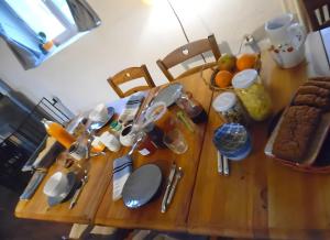 a wooden table with utensils on top of it at Ferme Des Montagnes Bleues in Bellegarde-en-Diois +17 photos