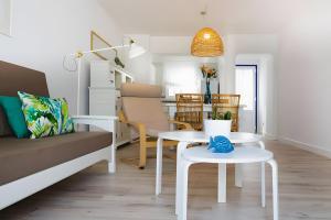 a living room with a couch and a table at Bungalow 11 - Caleta Campos in Arrieta
