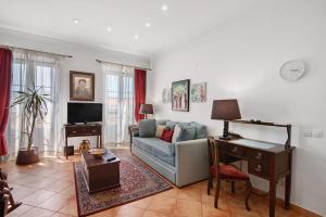 a living room with a couch and a desk at Estoi Heritage in Estói