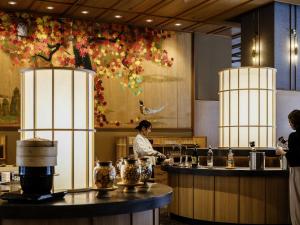 a woman standing in a kitchen preparing food at HanaMOMIJI in Jozankei