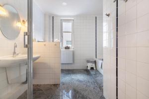 a white bathroom with a sink and a mirror at Villa Elysium in Heide +38 photos