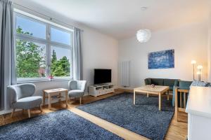 a living room with a couch and a tv at Villa Elysium in Heide