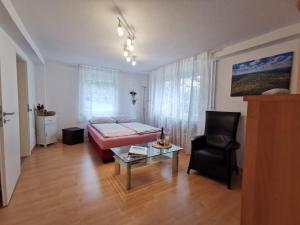 a bedroom with a bed and a chair and a table at Ferienwohnung Hogh, 55qm, Terrasse in Beuren +23 photos