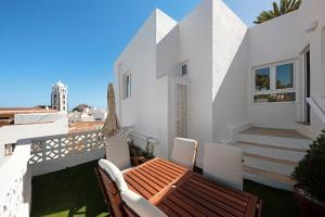 a patio with a wooden table and chairs on a balcony at Casa Sol 21 A Garachico in Garachico