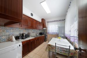 a kitchen with wooden cabinets and a table with chairs at Casa Linda in Olhão