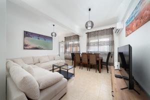 a living room with a couch and a dining room at Casa Linda in Olhão