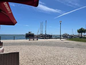 a dock with a bench and boats in the water at Casa Linda in Olhão