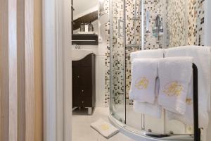 a bathroom with white towels and a glass shower at Prestigegoldresidence 2 - Old Town in Guimarães