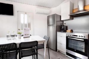 a kitchen with a table with chairs and a refrigerator at Prestigegoldresidence 2 - Old Town in Guimarães