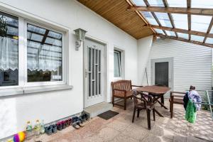 a patio with a table and chairs and a window at Bungalow 145 in Zeulenroda