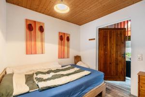 a bedroom with a bed and a wooden ceiling at Bungalow 145 in Zeulenroda