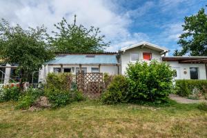 a white house with a fence in a yard at Bungalow 145 in Zeulenroda