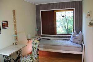 a room with a window with a bed and a chair at Ferienhaus am Belmermoor 167 in Brunsbüttel
