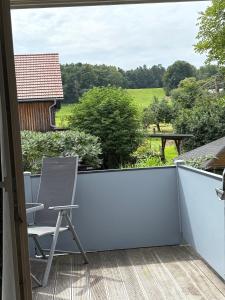a balcony with a chair and a view at Ferienwohung Rotkehlchen in Kurort Gohrisch +2 photos