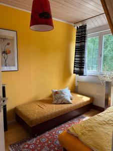 a bedroom with a bed and a yellow wall at Ferienwohung Rotkehlchen in Kurort Gohrisch
