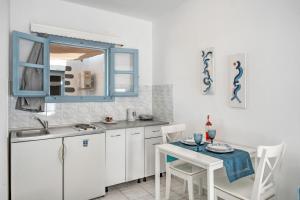 a kitchen with a table and a blue cabinet at Pico Bello Patmos 10 in Patmos
