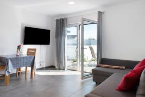 a living room with a couch and a table and a television at Ferienwohnung Maier in Bodman-Ludwigshafen