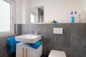 a bathroom with a sink and a mirror at Ferienwohnung Maier in Bodman-Ludwigshafen +22 photos