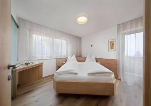 a bedroom with a bed and a large window at Wieser in Schenna
