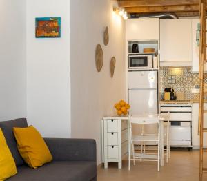 a living room with a couch and a small kitchen at Casa 5 Flores in Odeceixe