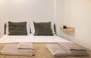 a bed with two pillows and two towels on it at Casa 5 Flores in Odeceixe