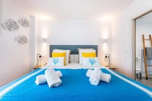 a bedroom with a large blue bed with pillows at Voramar in Pollença +12 photos
