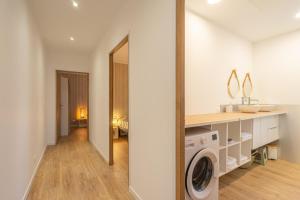a white laundry room with a washer and dryer at L'instant fleuri in Saint-Hippolyte