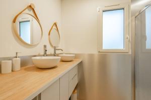 a bathroom with two sinks and a mirror at L'instant fleuri in Saint-Hippolyte +12 photos