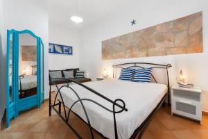 a bedroom with a large bed and a mirror at Kai Mālie Villasimius in Villasimius