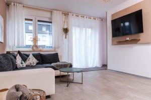 a living room with a couch and a tv at Melin Spa Suite – Wellness, Garten in Marl