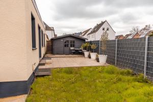 a backyard with a privacy fence and a patio at Melin Spa Suite – Wellness, Garten in Marl