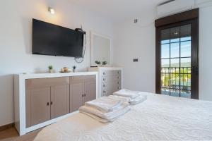 a bedroom with a large bed with a flat screen tv on the wall at Villa Oasis in Lora del Río +16 photos