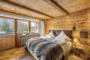 a bedroom with a bed in a room with wooden walls at Chalet Gipfelblick Inzell in Inzell