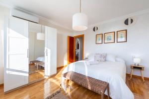 a bedroom with a white bed and a glass wall at Apartamento Loli in Aguadulce