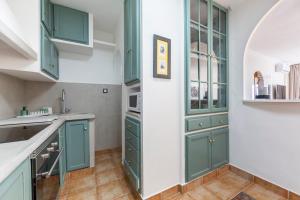 a kitchen with green cabinets and a sink at Apartamento Loli in Aguadulce