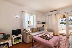 a living room with a couch and a tv at Casa O12 in Vilamoura