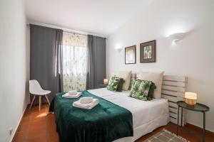 a bedroom with a bed with a green blanket at Casa O12 in Vilamoura +24 photos