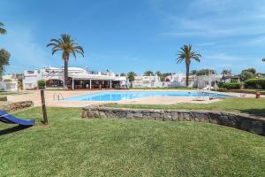 a swimming pool with palm trees and a resort at Casa O12 in Vilamoura