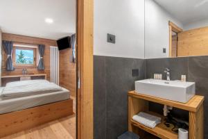 a bathroom with a bed and a sink in a room at Agriturismo Montespluga in Madesimo