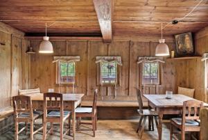 a dining room with wooden walls and tables and chairs at Berghof Moosen in Hart im Zillertal